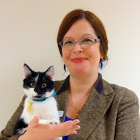 Bio photo of Karina King, smiling and holding a black and white cat